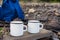 Two white campfire mug mockup with blue backpack