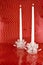 Two White Candles in Crystal Candleholders with Red Backgrounc