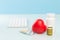 Two white cans with pills, tablet blisters, keyboard and red heart on a blue background. concept of medicine, cardiology
