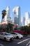 Two white cars at a crossroads at a traffic light at Pershing Square amid modern of