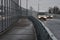 Two white cars, pictured in the blur, with the dipped-beam headlights on, drive across the viaduct