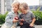 Two white Caucasian cute adorable funny children toddlers sitting together sharing apple food