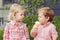 Two white Caucasian cute adorable funny children toddlers sitting together sharing ice-cream food