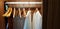 Two white clean bathrobes cloth or robe with wooden hanger and hanging inside dark brown closets