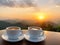 Two white cups of coffee with mountains view at sunrise