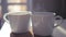 Two white cups stand on a stoop in the rays of the sun, slow pairs are spinning in the light. slowmotion