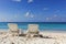 Two white deck chairs at tropical beach