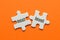 Two white details of puzzle with text Next Level on orange background, close up.
