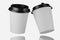 Two white disposable looms with a black plastic lid. White paper cup mockup for your design. White disposable cup mockup. 3d