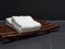 Two white folded towels were put on wooden lath tray or basket over dark or black background