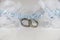 Two white gold wedding rings on white lace pad and blue garter