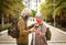 Two white-haired senior travelers with backpack on shoulders watching together at smartphone. Active retirees enjoying the walk in