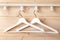 Two white hangers hang  near natural wooden wall