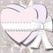 Two white hearts tied by ribbon with bow on background of blossoming lilia flowers