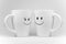 Two white mugs with facial expressions