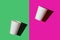 Two white paper biodegradable cups on colored backgrounds, top view, mock up