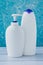 Two white plastic bottles on blue background. Hygienic concept. A group of clean containers on turquoise backdrop.