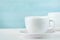 Two white porcelain teacups on white table show clean and simple design ideas, selective focus