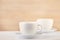 Two white porcelain teacups on white table show clean and simple design ideas, selective focus