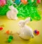 Two white porctlain rabbits near colorful bright eggs