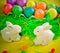 Two white porctlain rabbits near colorful bright eggs