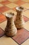 Two white rooks figures stands on a chessboard