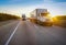 Two white semi trucks on road