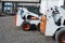 Two white skid steer loader at a construction site waiting of work. Industrial machinery. Industry.