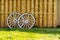 Two White Wagon Wheels against a wooden fence