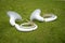 Two white wind musical instrument by a sousaphone-Helicon lying on the green grass in the Park.