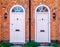 Two white wood residential front doors.