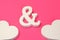 Two White Wooden Heart And Ampersand Symbol On Pink Background