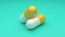 Two white-yellow pills rotating on green background. Seamless looping.