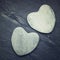 Two white zen hearts shaped rock on a tile