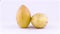 Two whole mature yellow pepino fruits. Rotating on the turntable. Isolated on the white background. Close-up.