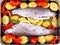 Two whole rainbow trout with red pepper, potato and lemon