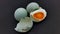 two whole salted duck eggs, one egg split and the shell empty