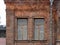 Two windows of the old mansion 19 century with brown bricks wall