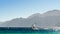 Two windsurfers ride on the background of high rocky mountains in Egypt Dahab South Sinai