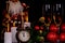 Two wine glasses with champagne, Santa Claus, clock and christmas ornaments on a black background