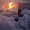 Two wineglasses on beach near campfire.