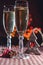 Two wineglasses of champagne and new year`s decoration and cinnamon on the bokeh background