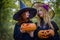 Two witches standing and holding orange pumpkin