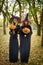 Two witches standing and holding orange pumpkin