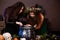 Two witches with tousled hair brew a potion in a cauldron with rats, halloween concept