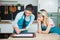 Two woman bakers dropping macaroons on mat