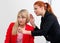 Two woman colegues gossip in office