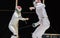 Two woman fencing athletes fight