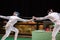 Two woman fencing athletes fight