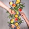 Two woman hands holding seasonal organic fruits from garden: apples, pears, peaches, plums with leaves , top view. Flat lay.